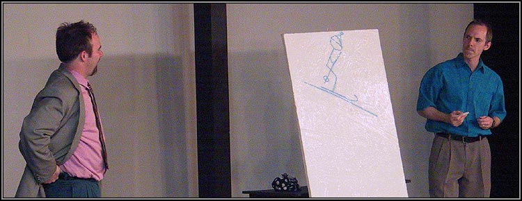 After Serge's challenge and invitation, Marc (Craig Bentley) draws a stick figure on Serge's painting while Yvan (Matthew Lawler) looks on in horrified amusement.