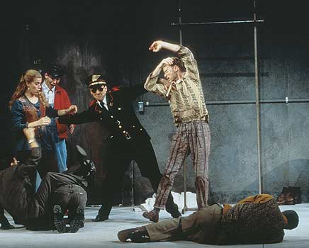 Policeman (John Hines) begins the melee at the drug treatment center.