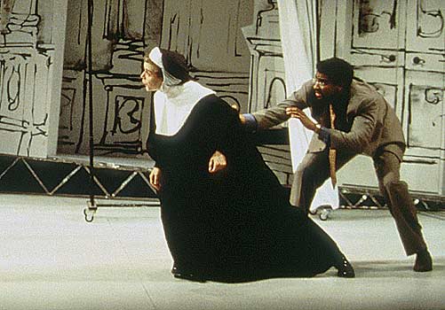 Elisa (Amy Cronise), held back by Professor Ridolfi 
						(Obi Ndefo) taunts Cardinal Stillaci.