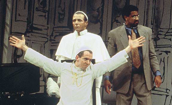 The Pope (Paul Niebanck) is stuck with arms outstretched.